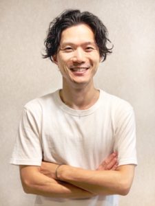 腕を組む男性